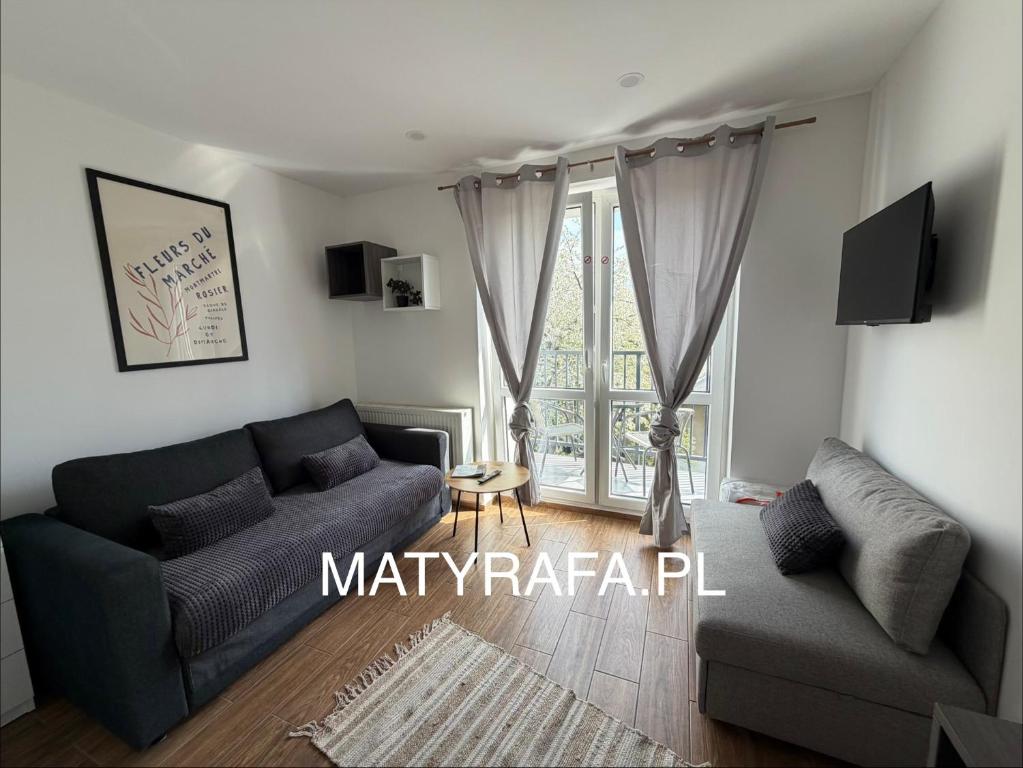 a living room with a couch and a window at ApartmentsByMatyrafa-XV in Tarnowskie Góry
