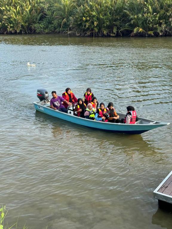 a group of people in a blue boat on the water at CD Garden Cottage in Kota Bharu