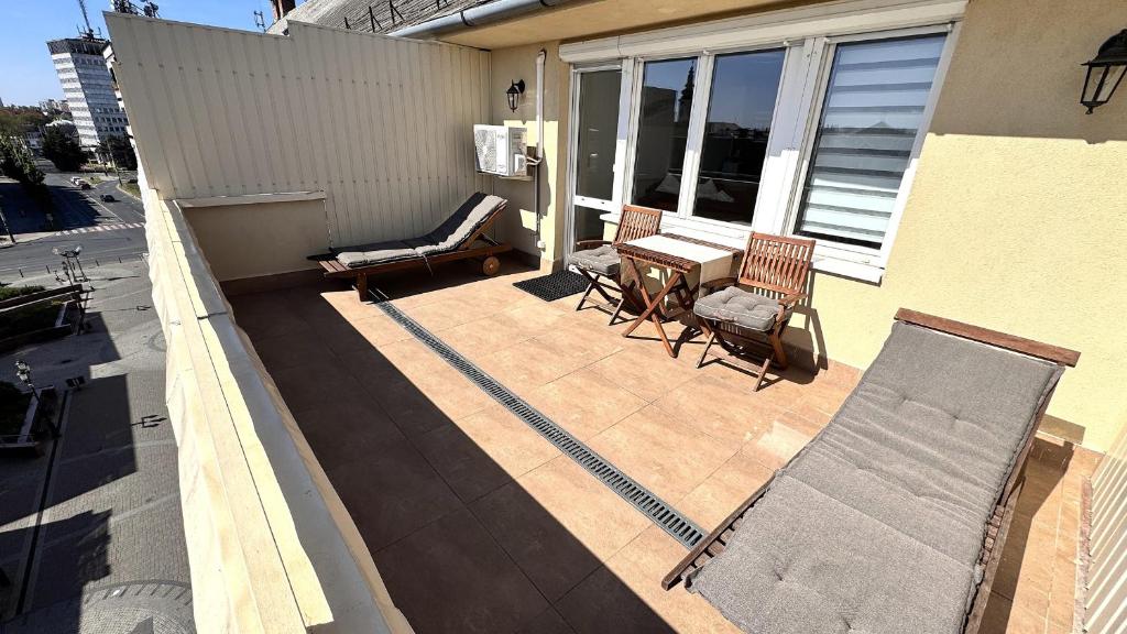 a patio with two chairs and a table on a house at Rest House Apartman in Nyíregyháza