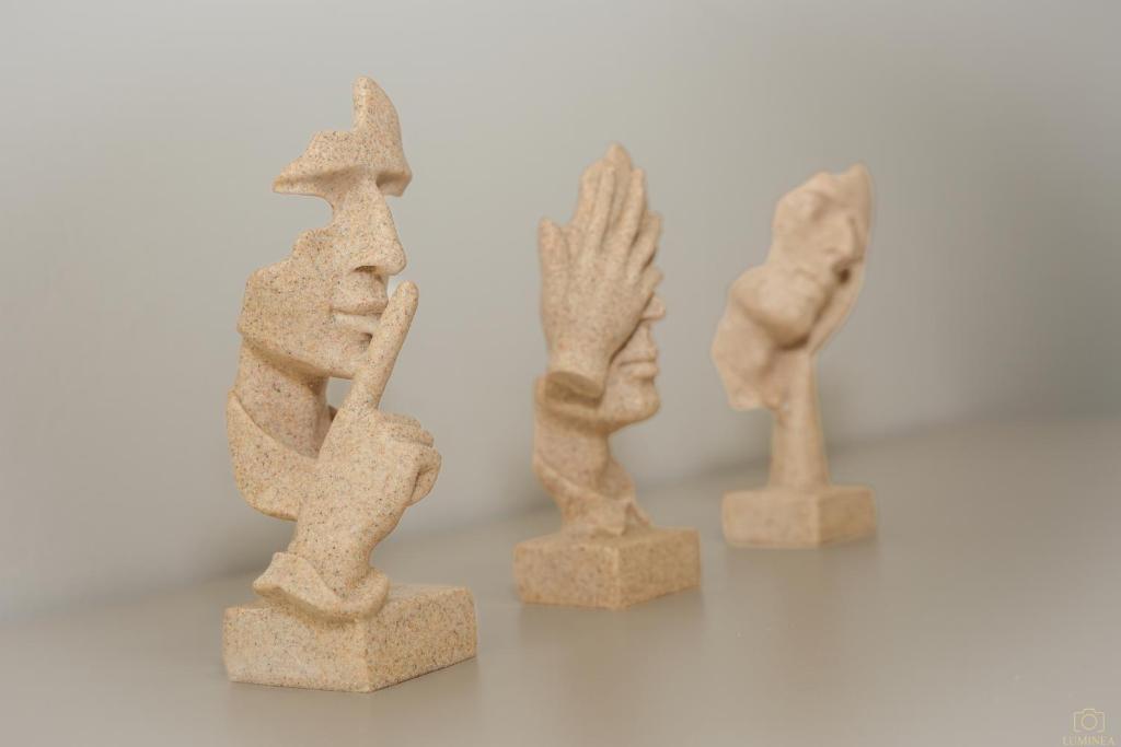 a group of three stone statues on a table at Island Pearl in Mali Lošinj