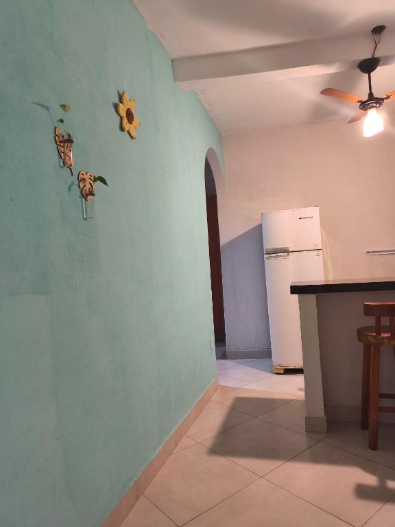 a kitchen with a green wall and a refrigerator at Casa da Di in Lençóis