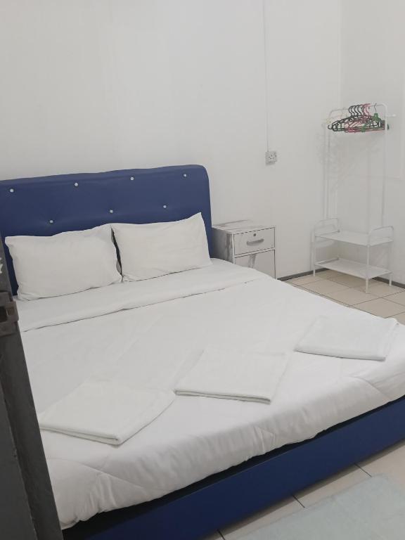 a large bed with a blue headboard in a bedroom at Mulu D Cave Homestay Room 2 in Mulu