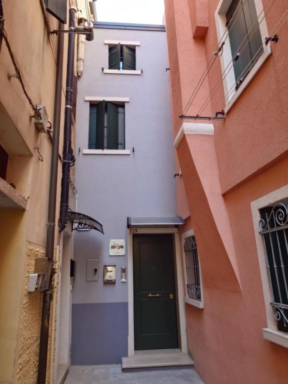 a narrow alley with a door in a building at Angolo Del Paradiso in Chioggia
