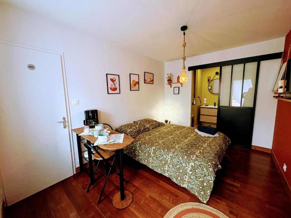 a bedroom with a bed and a table in it at Chambre du Cotentin in Créances