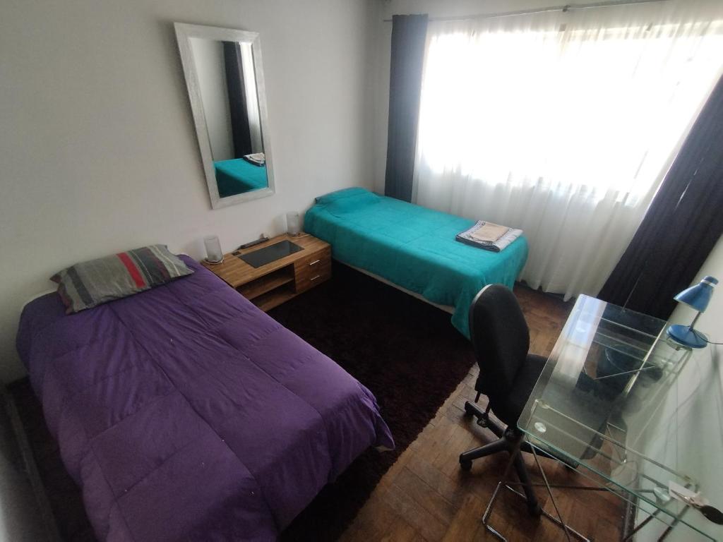 a room with two beds and a desk and a mirror at Habitación Doble en Dpto compartido in Santiago