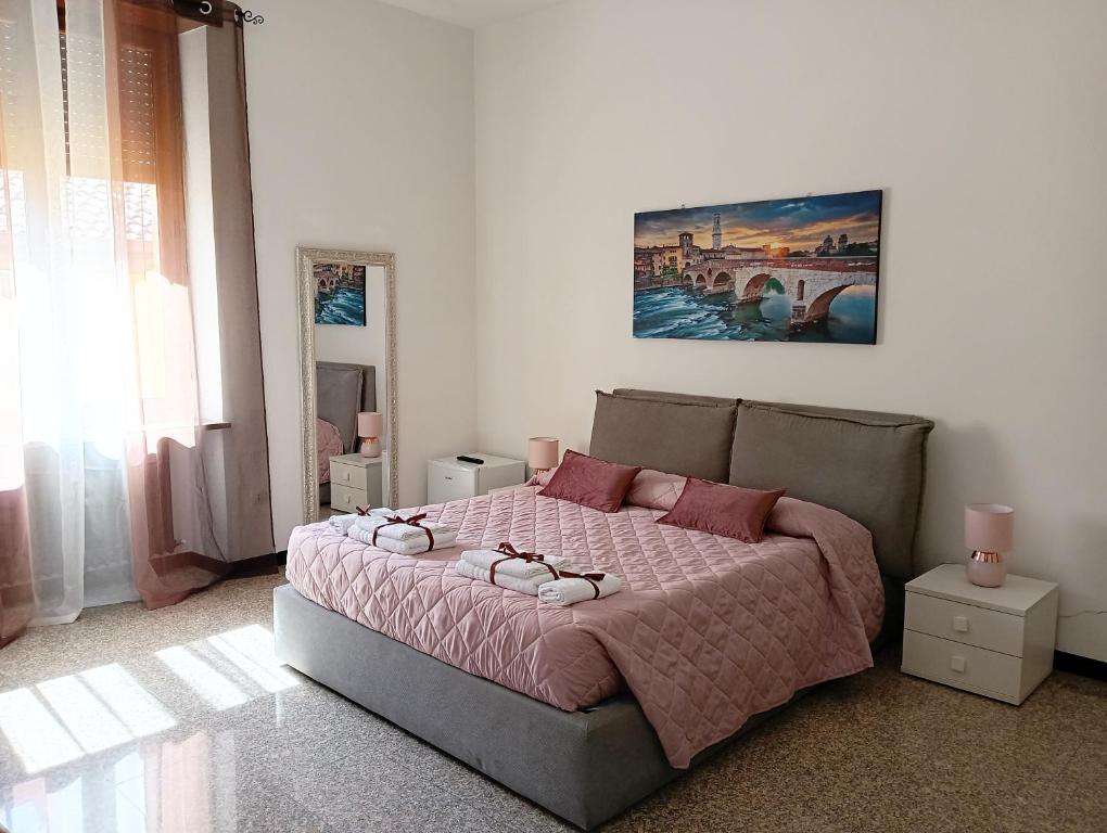a bedroom with a bed with a pink comforter at Cattaneo 19 Rooms in Verona