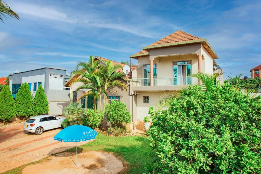 a house with a blue umbrella in front of it at THELIGHT SUITES KIGALI Rwanda in Kigali