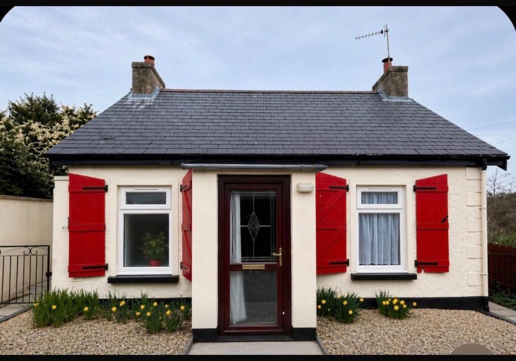 a red and white house with a black roof at Hallow Cottage in Newtownstewart
