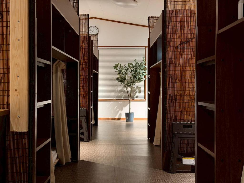 a hallway with open doors and a plant at ura San Jose in Okayama