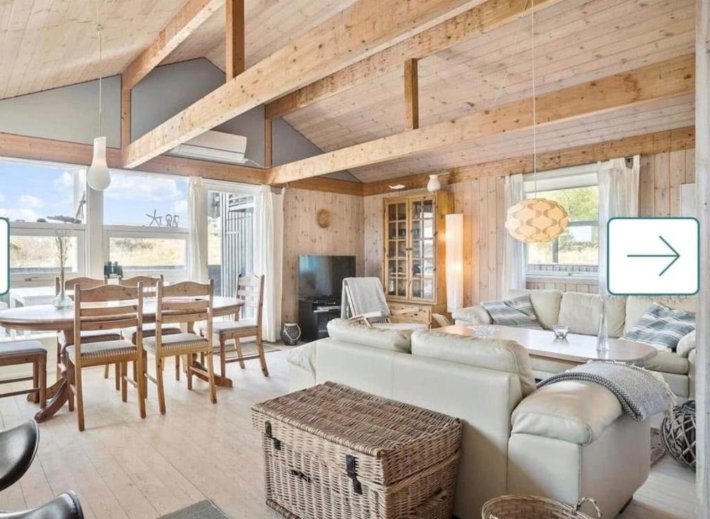 a living room with a white couch and a table at Feriehus Kornblomst in Tversted