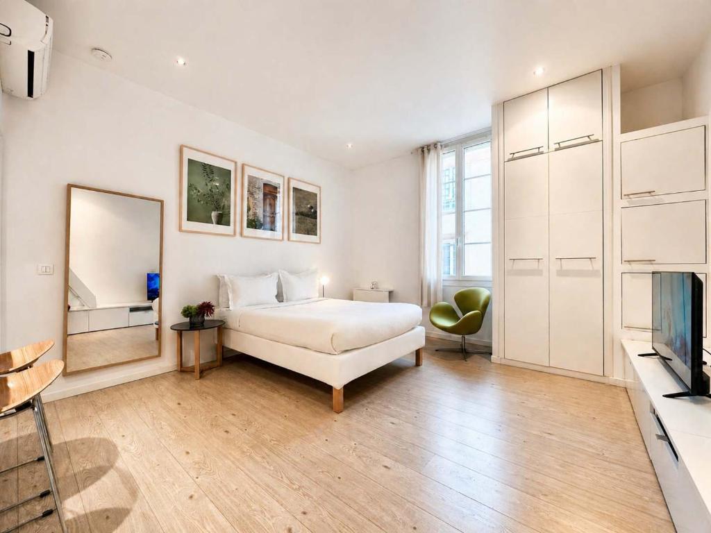 a white bedroom with a bed and a television at Èrsextius ABB Aix-en-Provence in Aix-en-Provence