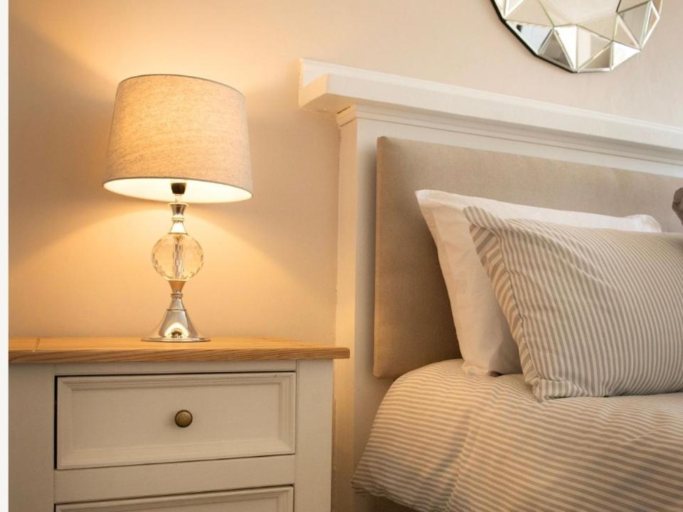 a lamp on a night stand next to a bed at Buckie Central 2 bed Retreat 24 high street in Buckie