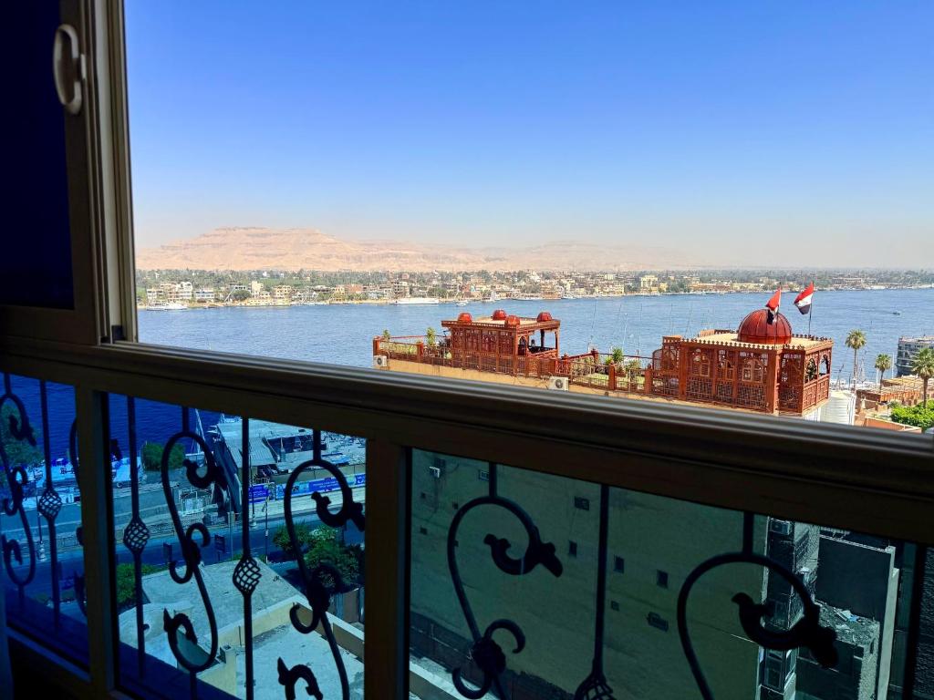 a balcony with a view of a boat in the water at Winter House in Luxor