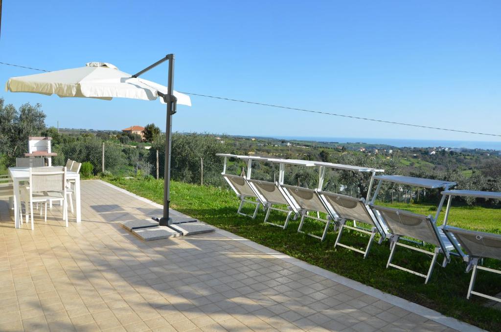 a group of chairs and a table and an umbrella at Sea View Villa, 4-6 Guests in Cupra Marittima