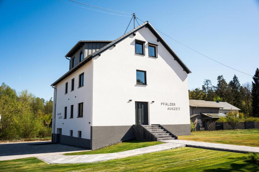 a white house with a black roof at Ferienwohnung Lindelskopf in Ludwigswinkel