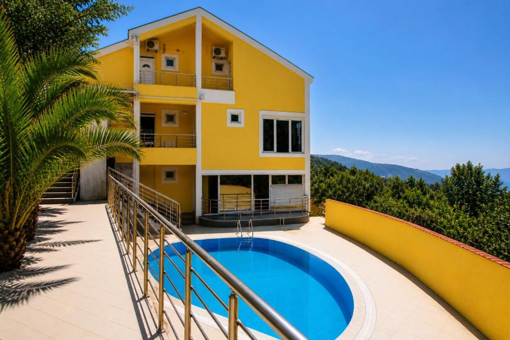 a villa with a swimming pool in front of a building at Crypto Hills Montenegro in Herceg-Novi