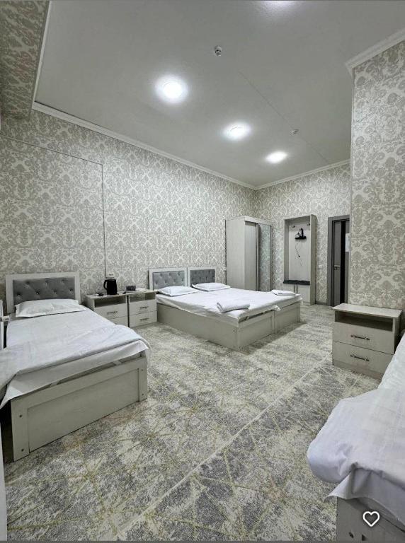 a large bedroom with two beds in it at Lola Hotel in Yangiyer