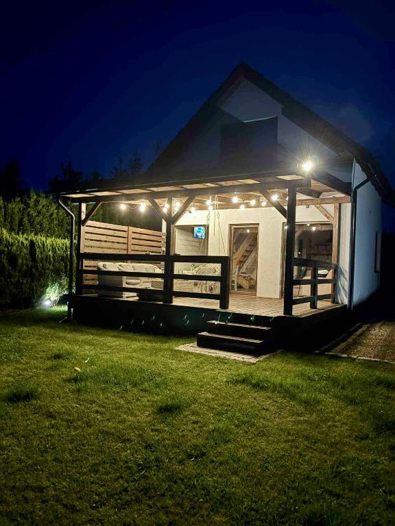 a house with lights on it in a yard at night at SOCHÓWKA nad Jeziorem Skarlińskim in Kurzętnik