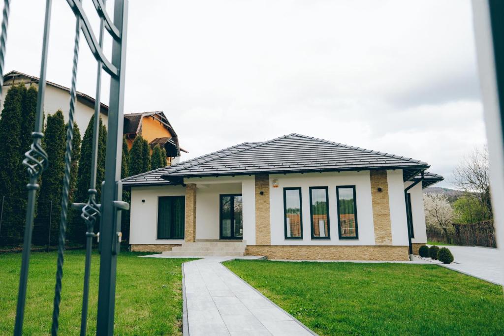 a small house with a grass yard in front of it at Casa DIAMOND LUX&SPA in Sovata