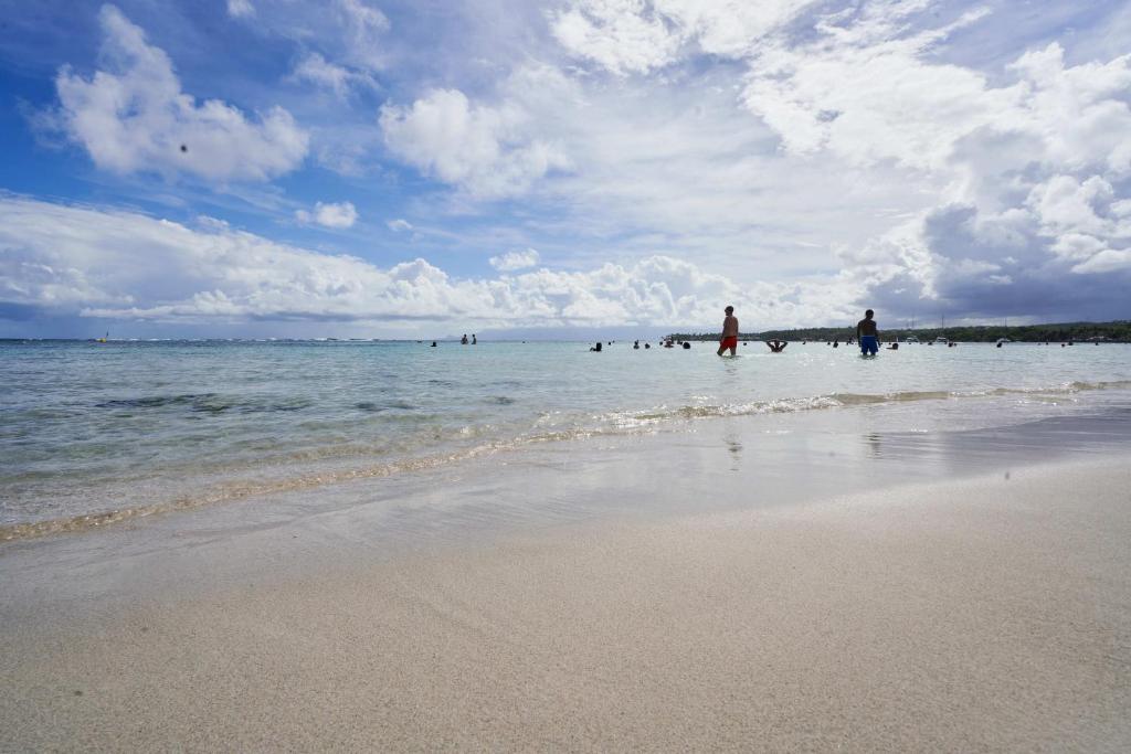 a group of people in the water at the beach at Résidence Le Lagon in Sainte-Anne