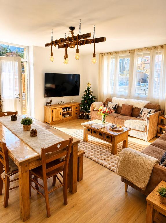 a living room with a couch and a table at Le Terrier- Chaleureux avec Jardin privatif et parking pour 2 voitures in Briançon