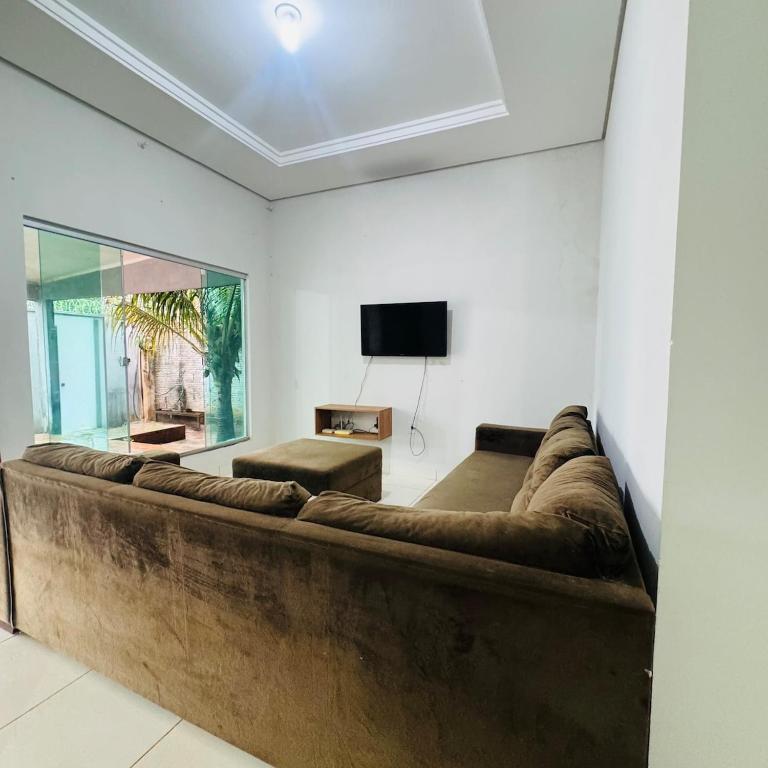 a living room with a large couch and a tv at casa mobiliada em gurupi in Gurupi