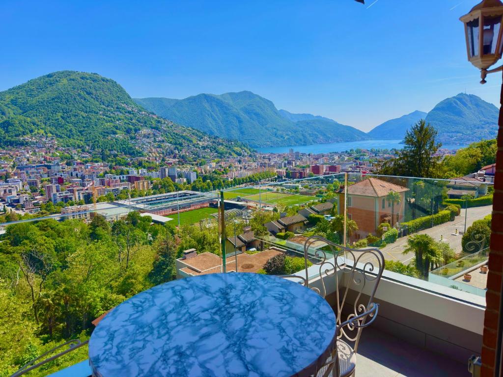 a view of a city from the balcony of a house at BELVEDERE - Lakeview Apartment 10 min from Lugano in Porza