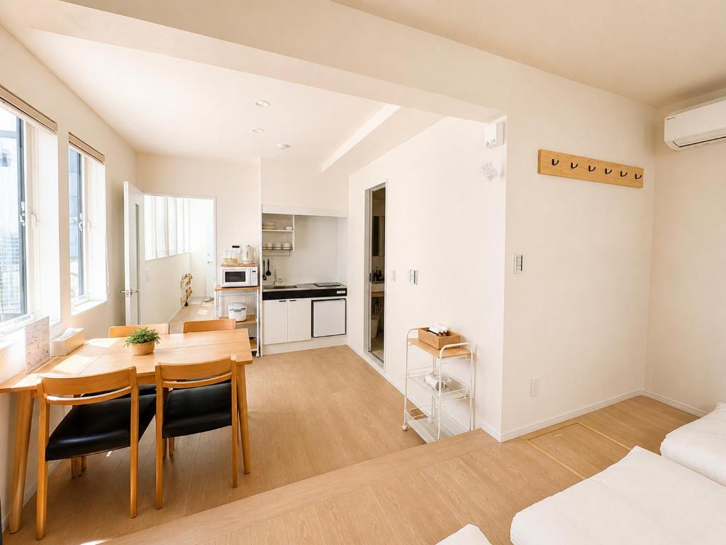 a living room with a dining room table and a kitchen at 北鎌倉駅徒歩圏 観光便利 最大7名 2寝室 広々滞在 101 in Kamakura