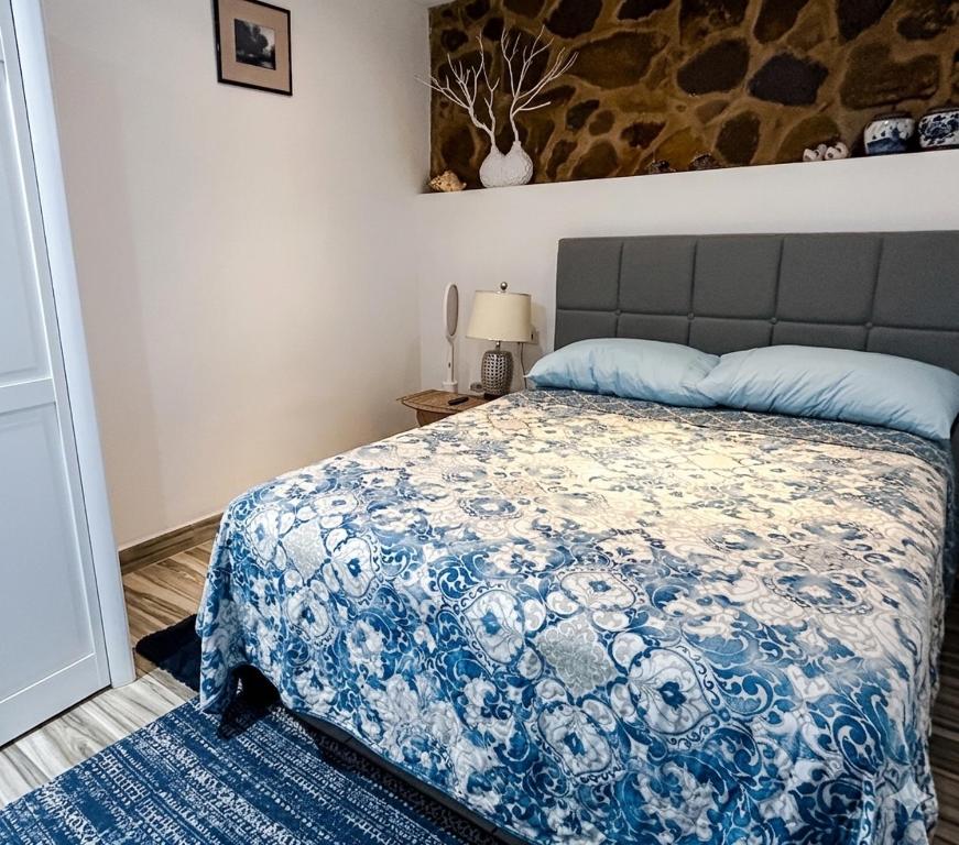 a bedroom with a bed with a blue and white blanket at Studio Bella in Philipsburg