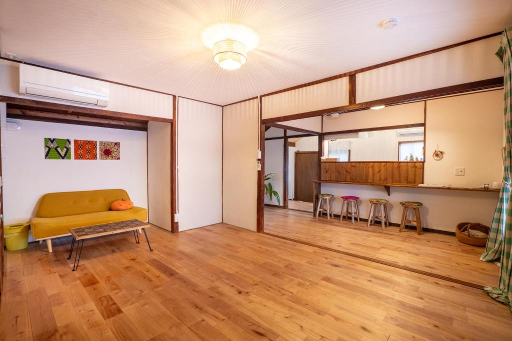 a living room with a couch and a table at 離島の宿 Nawanawa Backpackers in Matsuyama