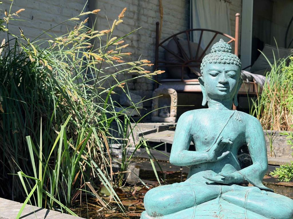 a statue of a meditating woman in a garden at L'Alterre Durbuy in Durbuy