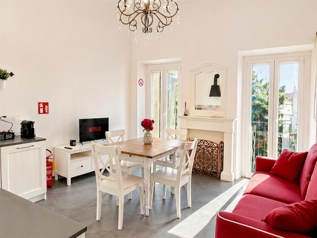 a living room with a table and a red couch at Royal Nest Venaria Reale in Venaria Reale