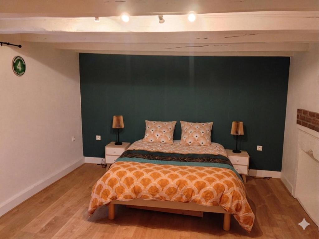 a bedroom with a large bed with a green wall at Maison de charme a moye in Moye