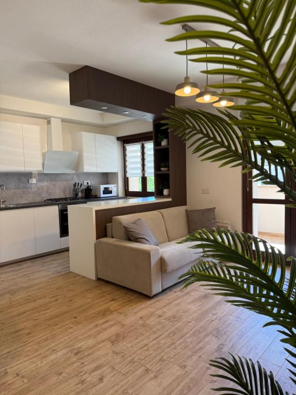 a living room with a couch and a kitchen at Maison Piave 35 in Olbia
