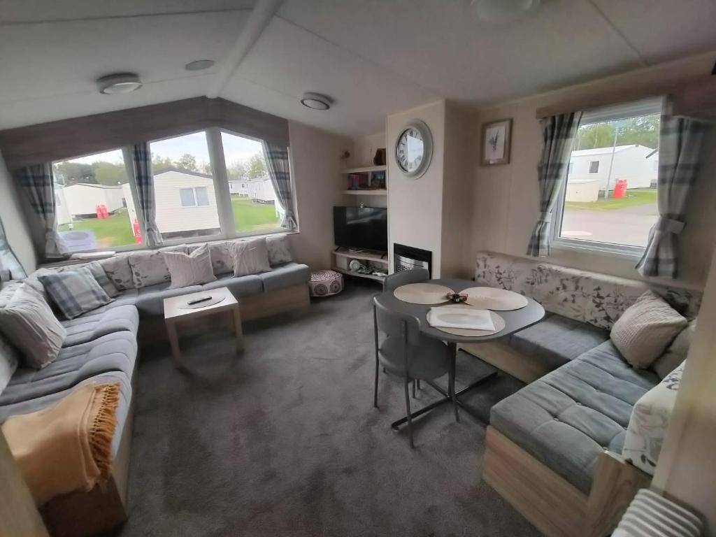 a living room with a couch and a table at Seton Sands caravan close to Edinburgh in Port Seton