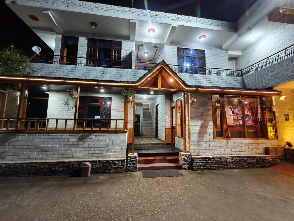 a brick building with a balcony on the front of it at Chander Guest House in Kasol