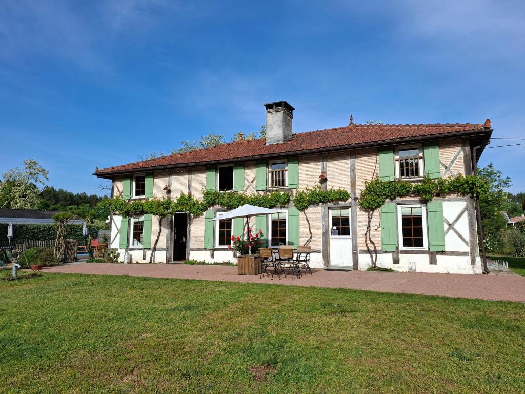 a large house with green and white at La résinière de pirique in Parentis-en-Born