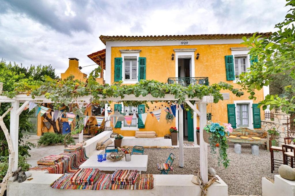 a house with an outdoor patio with tables and chairs at Villa Ochre - Rustic Retreat in Tsilivi