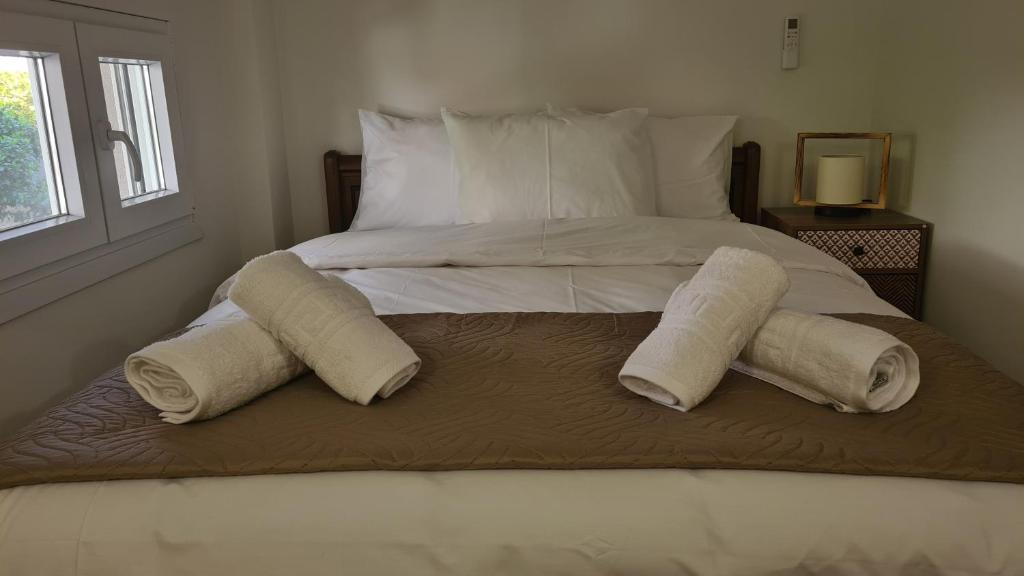 a bed with two pillows and towels on it at JP Luxury Apartment 2 in Chios