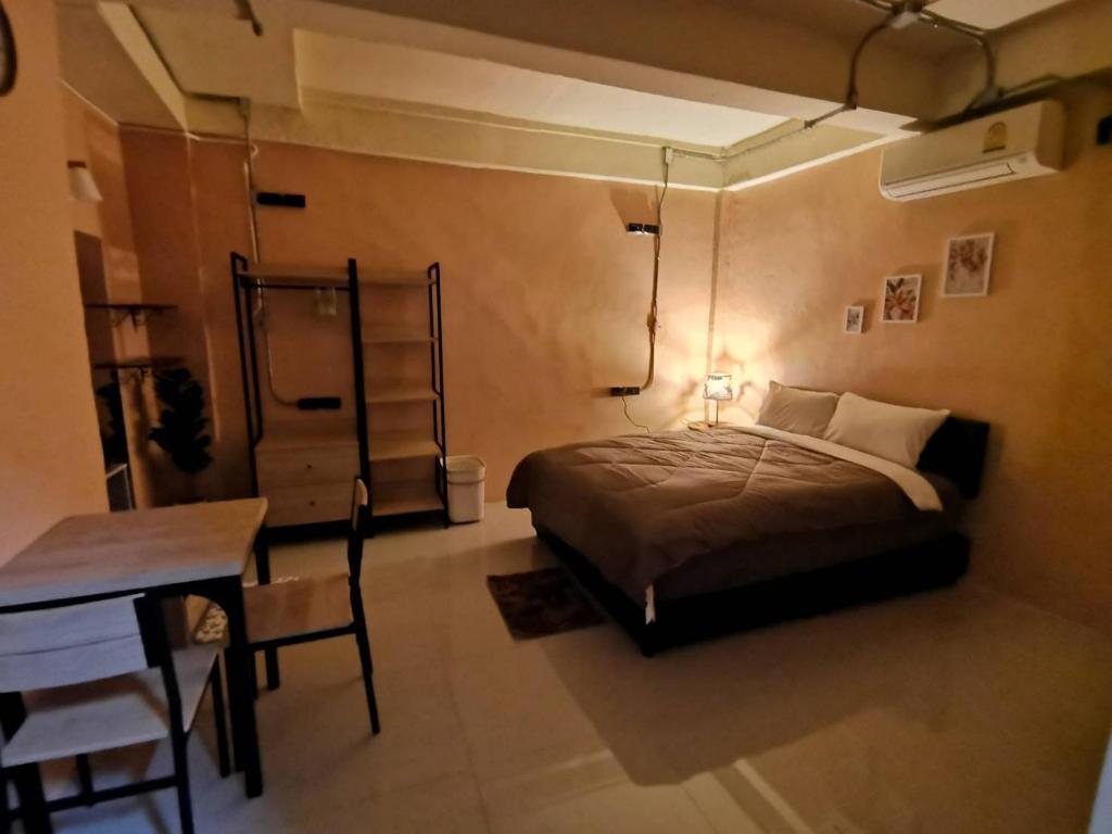 a bedroom with a bed and a table and a desk at O'Kane's Pub and Hostel in Chiang Rai