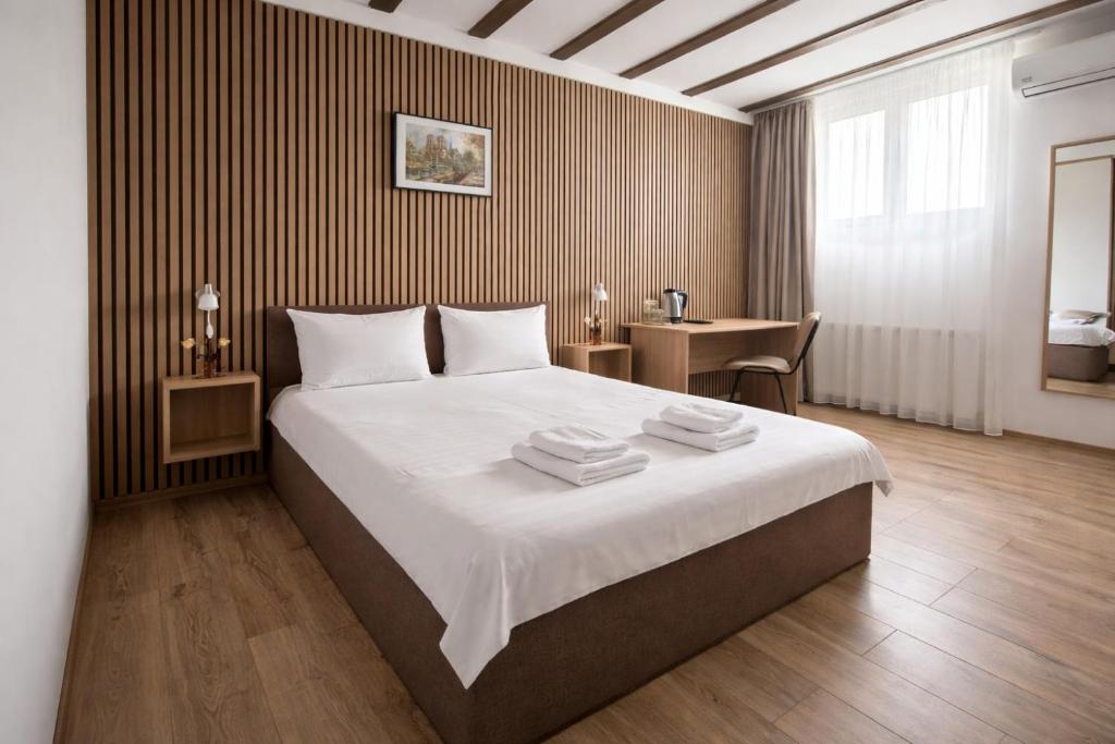 a bedroom with a large bed with towels on it at Confort INN in Otopeni