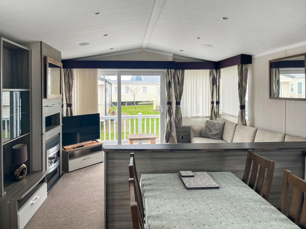 a living room with a dining table and a couch at Pebbles in Pakefield