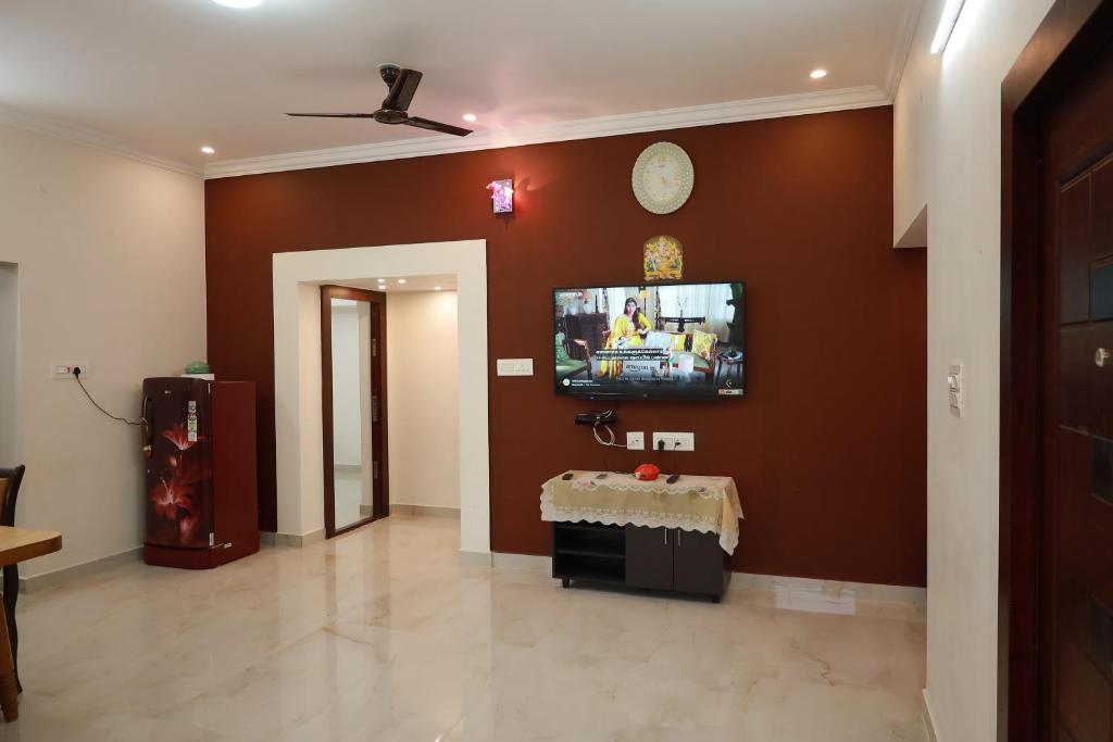 a living room with a tv on a brown wall at Mercury JKR Residency in Yelagiri