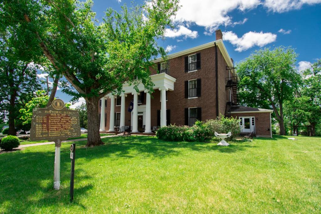 a large brick house with a sign in the yard at Beaumont Inn in Harrodsburg