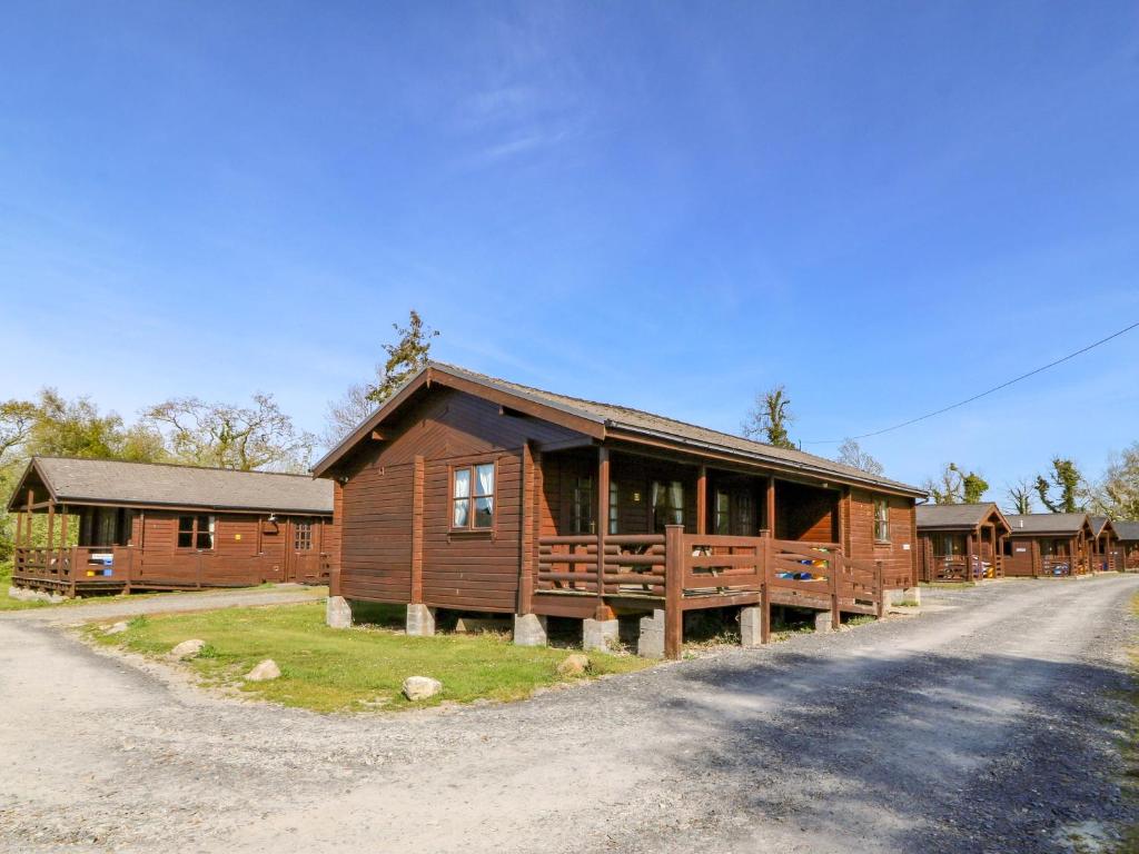 a large log cabin with a road in front of it at Lodge 2 - Bron Eifion in Criccieth