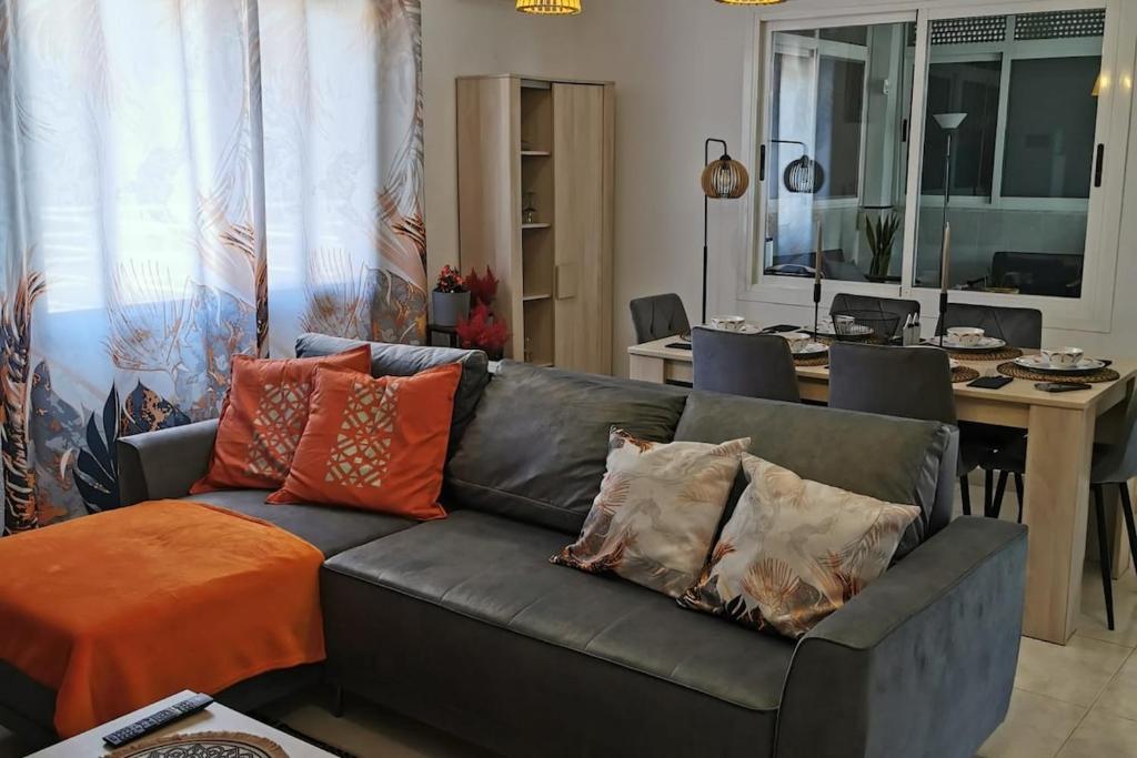 a living room with a black leather couch with pillows at Casa del Sol in Gandía
