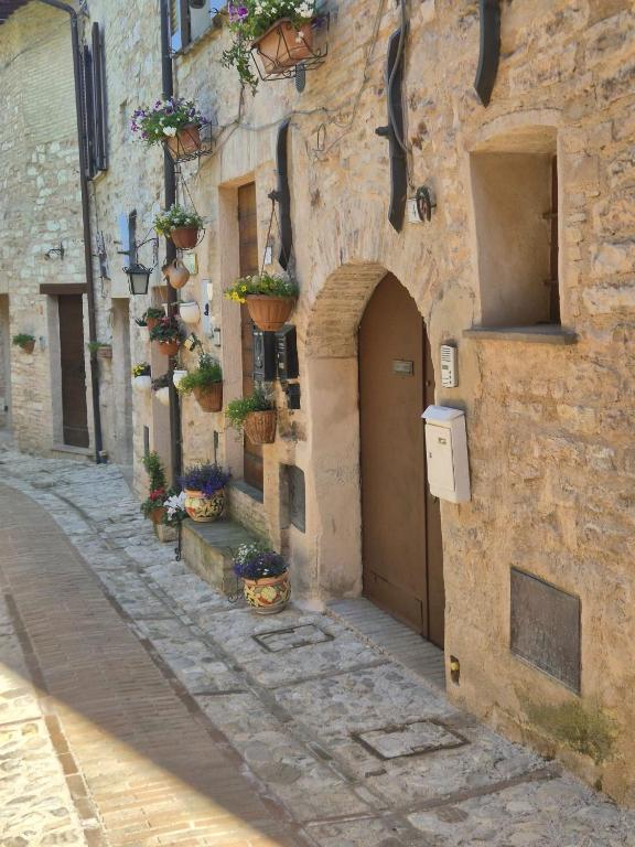 an alley with potted plants on the side of a stone building at Loft in Love in Spello