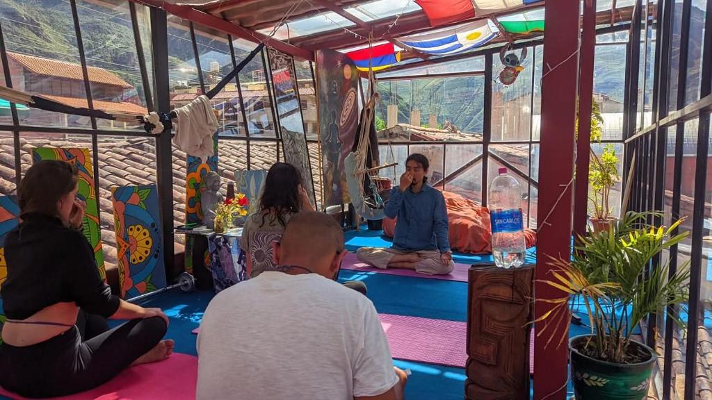 a group of people sitting in a meditation room at Aguaymanto pisac hostel in Pisac
