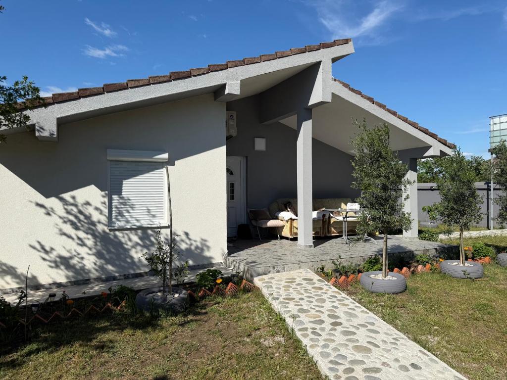 a white house with a patio and a table at Apartment Oki Ulcinj in Donji Štoj