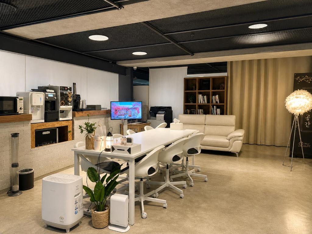 a room with a table and chairs and a tv at Orago Stay Hotel in Suwon